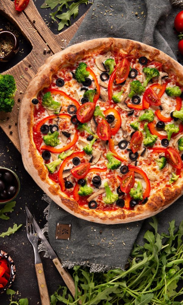 vegetarian-pizza-with-broccoli-red-pepper-tomato-black-olives-wooden-cupboard